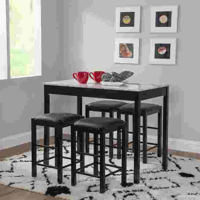 Black tavern set with faux marble top and four stools in a dining area.