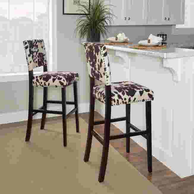 Two Cypress Bar Stools with black and white cowhide pattern upholstery in a kitchen