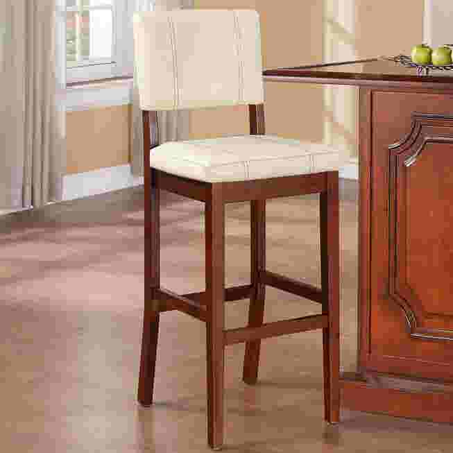 Cream upholstered bar stool with dark wood frame in a kitchen setting