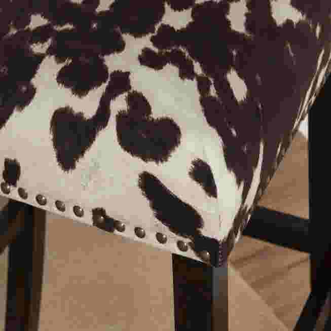Close-up of the black and white cowhide pattern upholstery on the bar stool