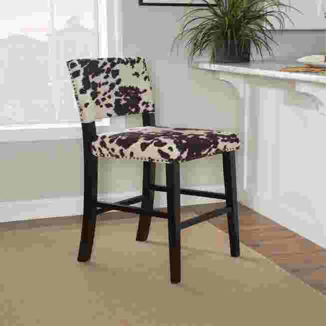 Cypress Bar Stool with black and white cowhide pattern upholstery in a kitchen