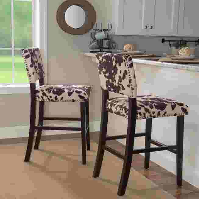 Two Cypress Bar Stools with black and white cowhide pattern upholstery in a kitchen