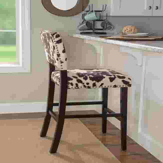 Cypress Bar Stool with black and white cowhide pattern upholstery in a kitchen