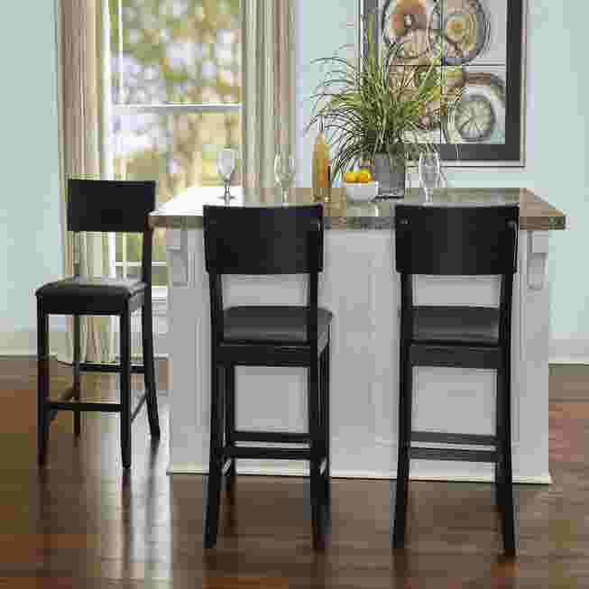 Three black bar stools at a kitchen island