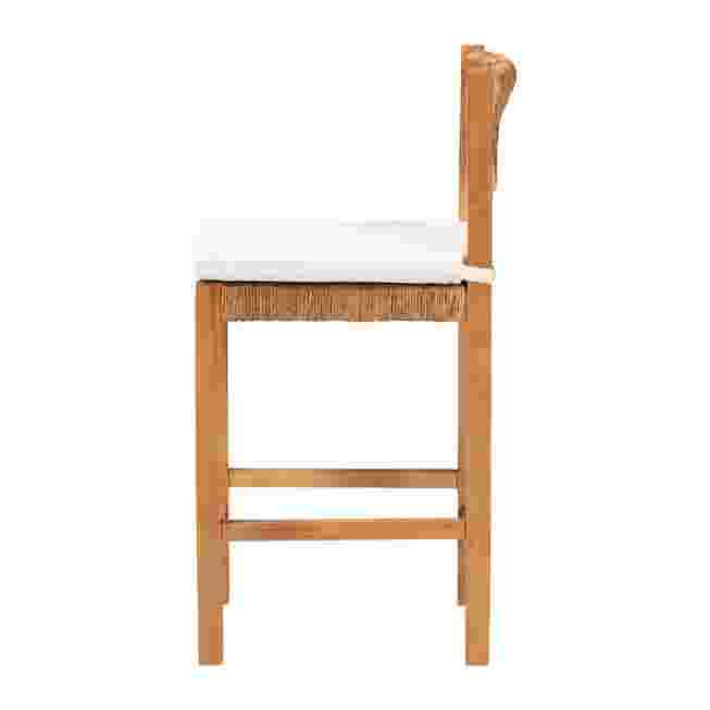 Side view of woven seagrass counter stool with wood frame and white seat cushion.